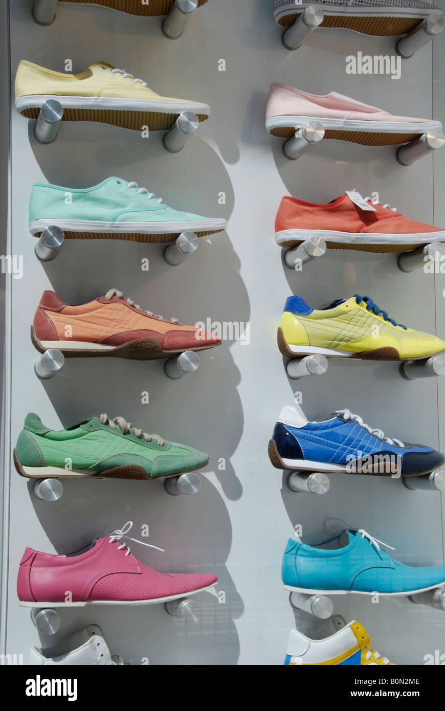 Zahlreiche bunte Sneaker Art Schuhe im Schaufenster anzeigen in London High Street Stockfoto