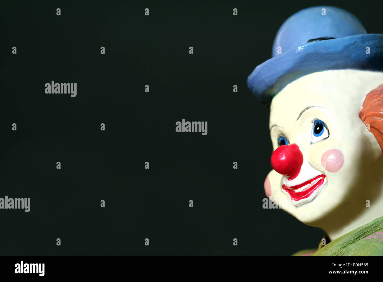 ein Spielzeug-Clown Gesicht vor einem dunklen Hintergrund Stockfoto