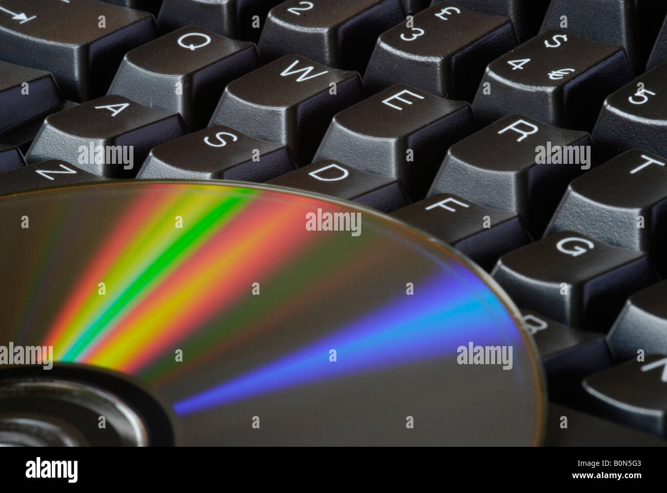 Nahaufnahme der Computertastatur und reflektierende Seite der DVD Disk 2008 Stockfoto