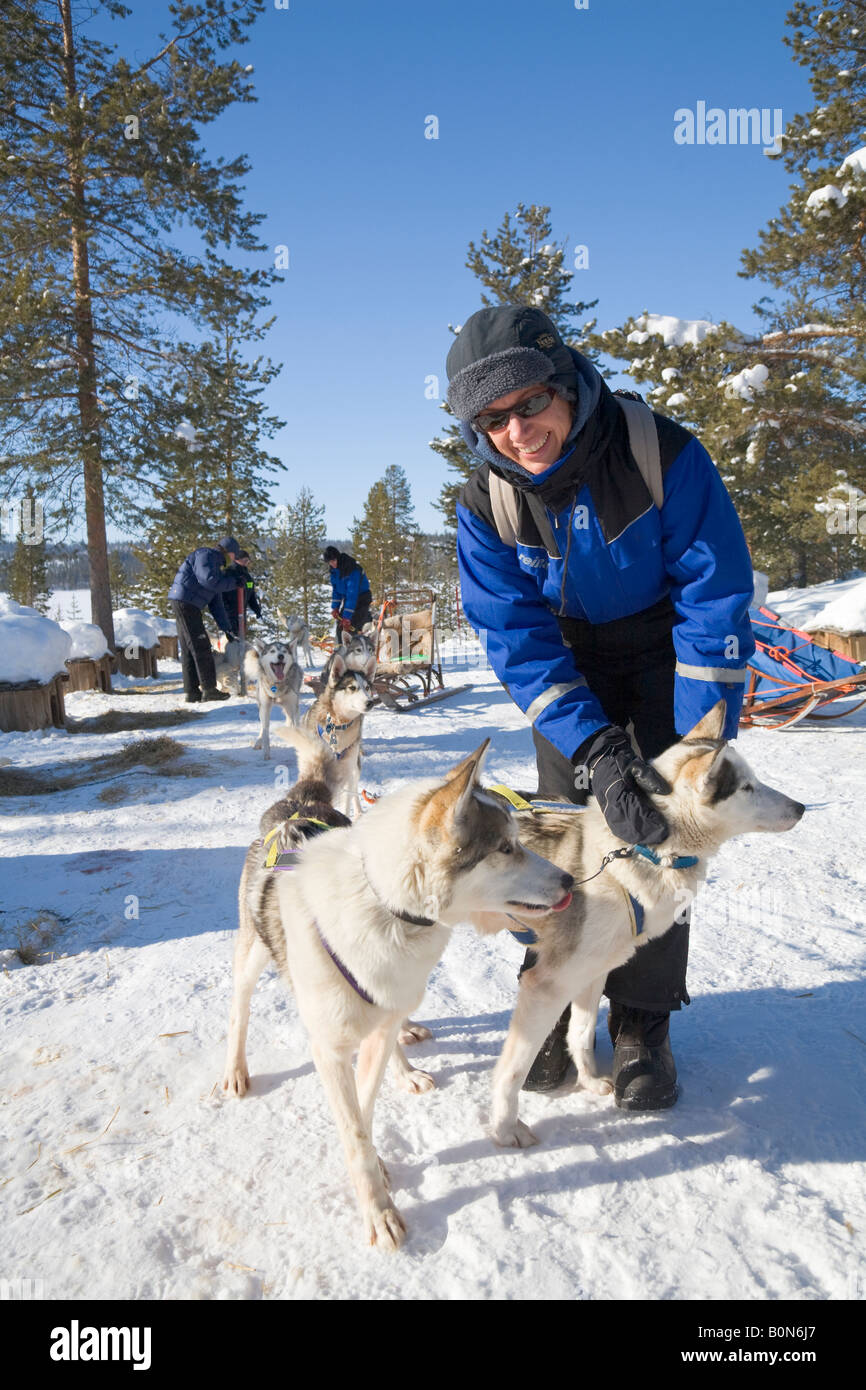 Eine Frau streichelt einen Husky in eine Hurtigrutentickets Fahrt mit sibirischen Huskies in winterlichen Lappland / nördlichen Schweden Stockfoto
