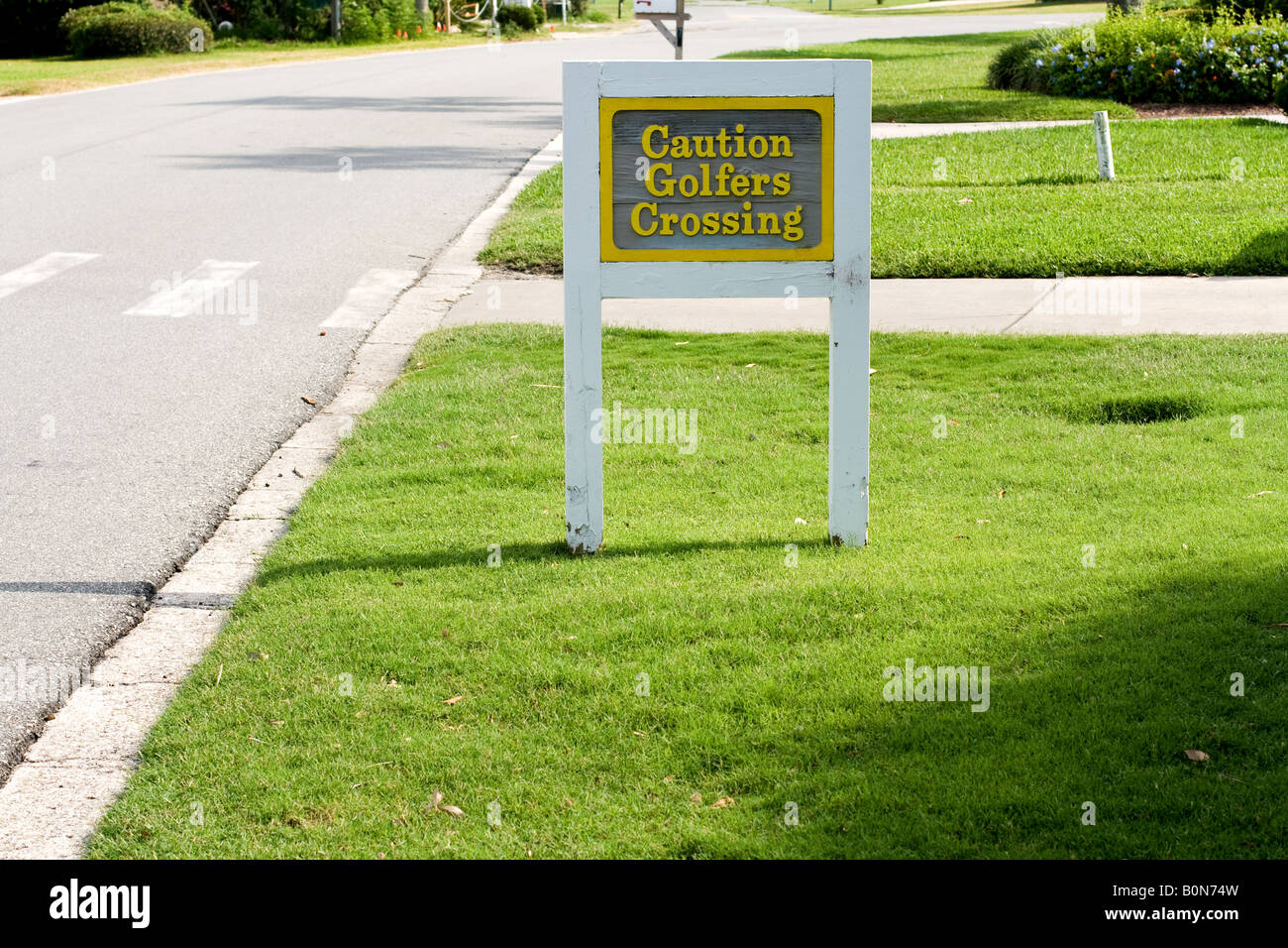 Grau-Schild mit gelber Schrift, mit weißem Rand, die sagen "Achtung Golfer überschreiten" in Ponte Vedra Beach, Florida, USA Stockfoto