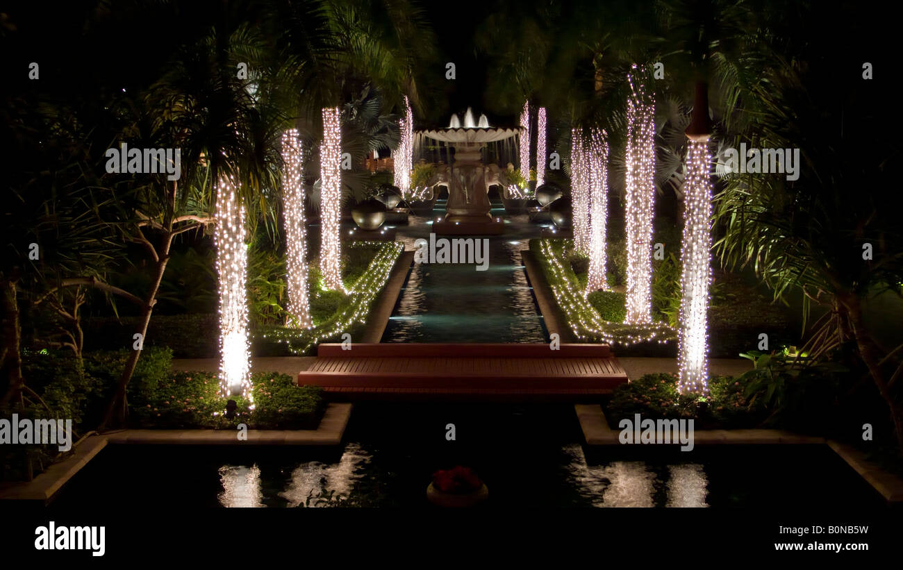Der Garten mit Pool und beleuchteten Springbrunnen in der Nacht in The Hyatt Regency Hotel and Spa in Hua Hin in Thailand Stockfoto