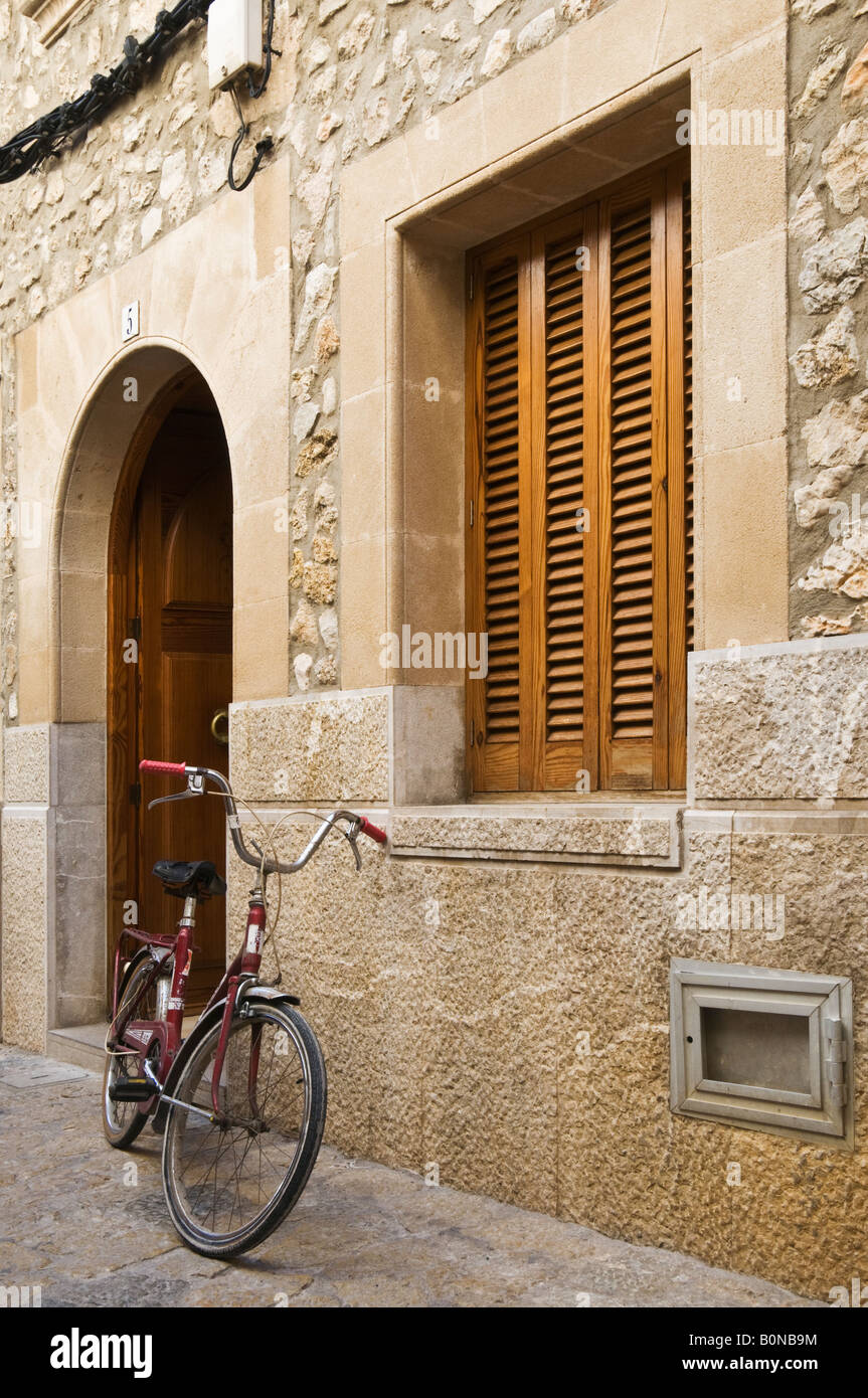 Ein Fahrrad gegen eine Wand in einer Straße von Pollensa, Mallorca, Spanien. Stockfoto