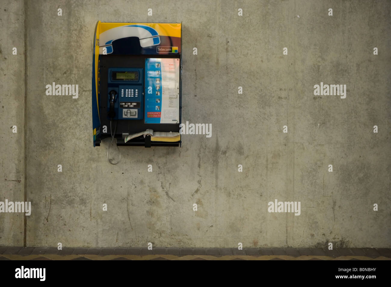 Telefon und Verzeichnis auf Betonwand Stockfoto