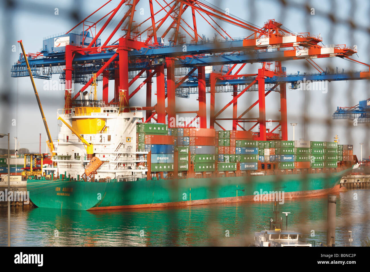 Containerschiff hinter Zaun im Hafen von Hamburg Stockfoto