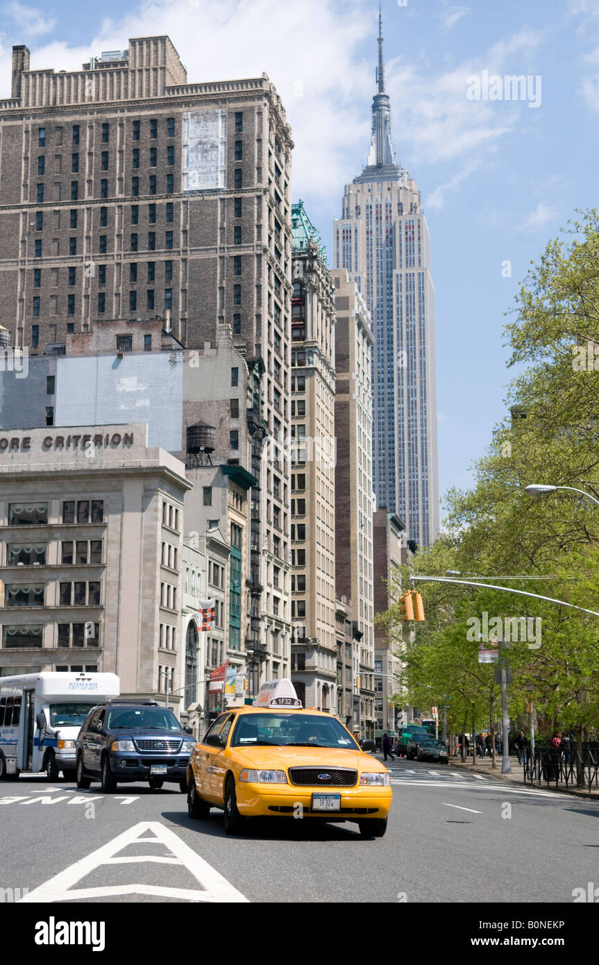 Ein New York Taxi Cab Überfahrt von Broadway, Fifth Avenue in New York mit dem Empire State Building im Hintergrund Stockfoto