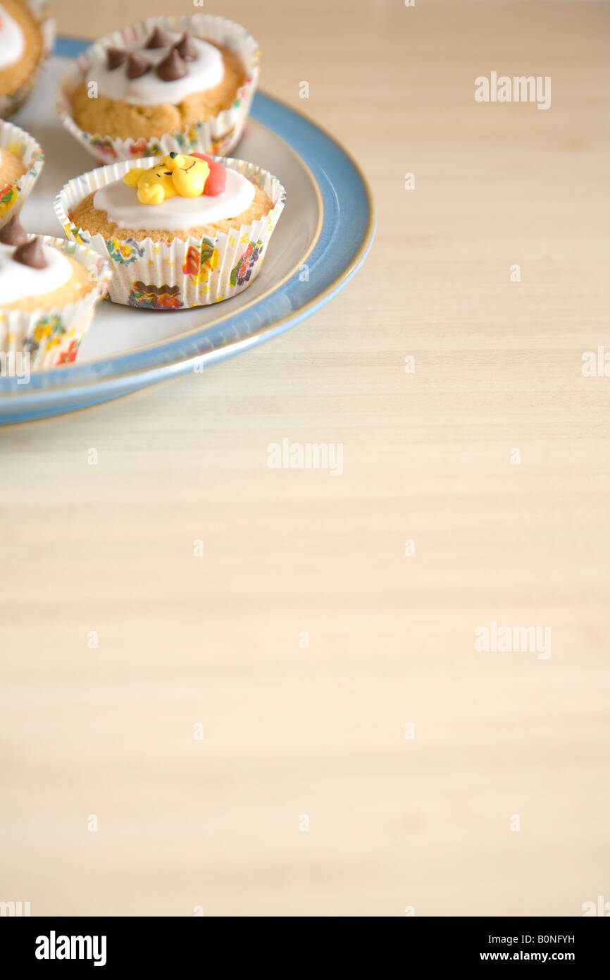 Bunte Muffins auf einem blau-weißen Porzellanteller angeordnet Stockfoto