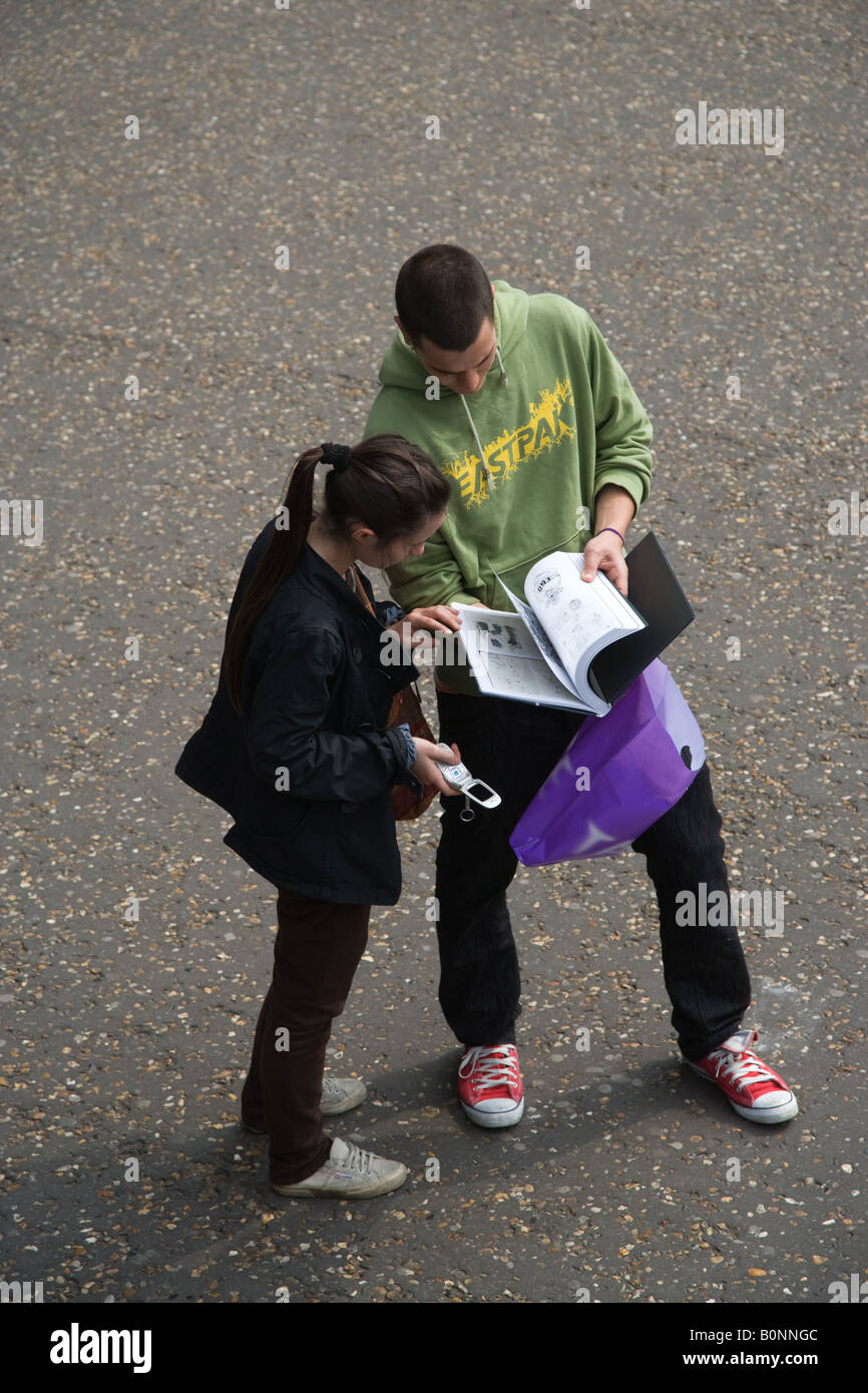 Ein junges Paar lesen einen Reiseführer in der Straße außerhalb der Tate Modern, London UK Stockfoto