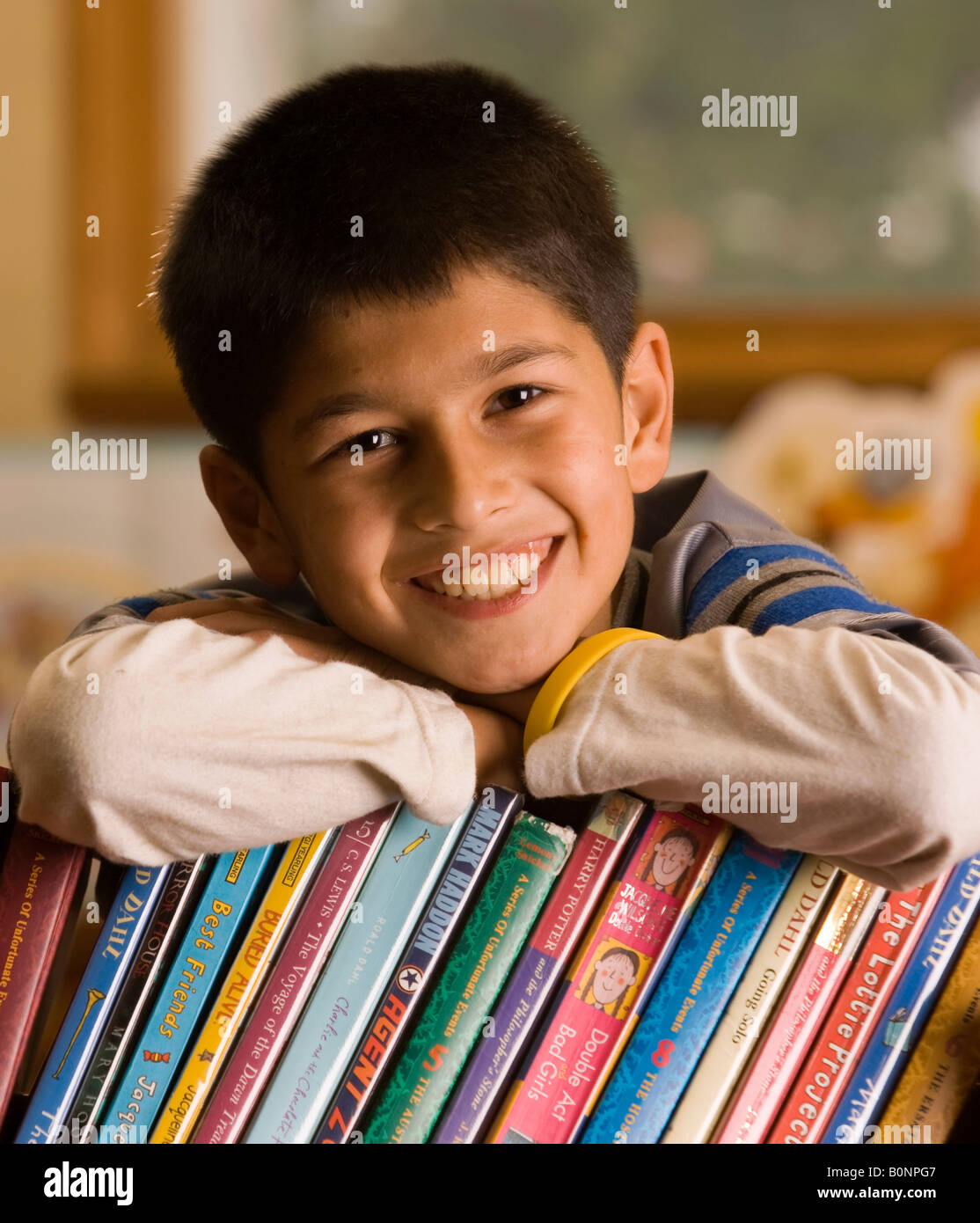 Bildnis eines Knaben stützte sich auf Bücher und lächelnd Stockfoto