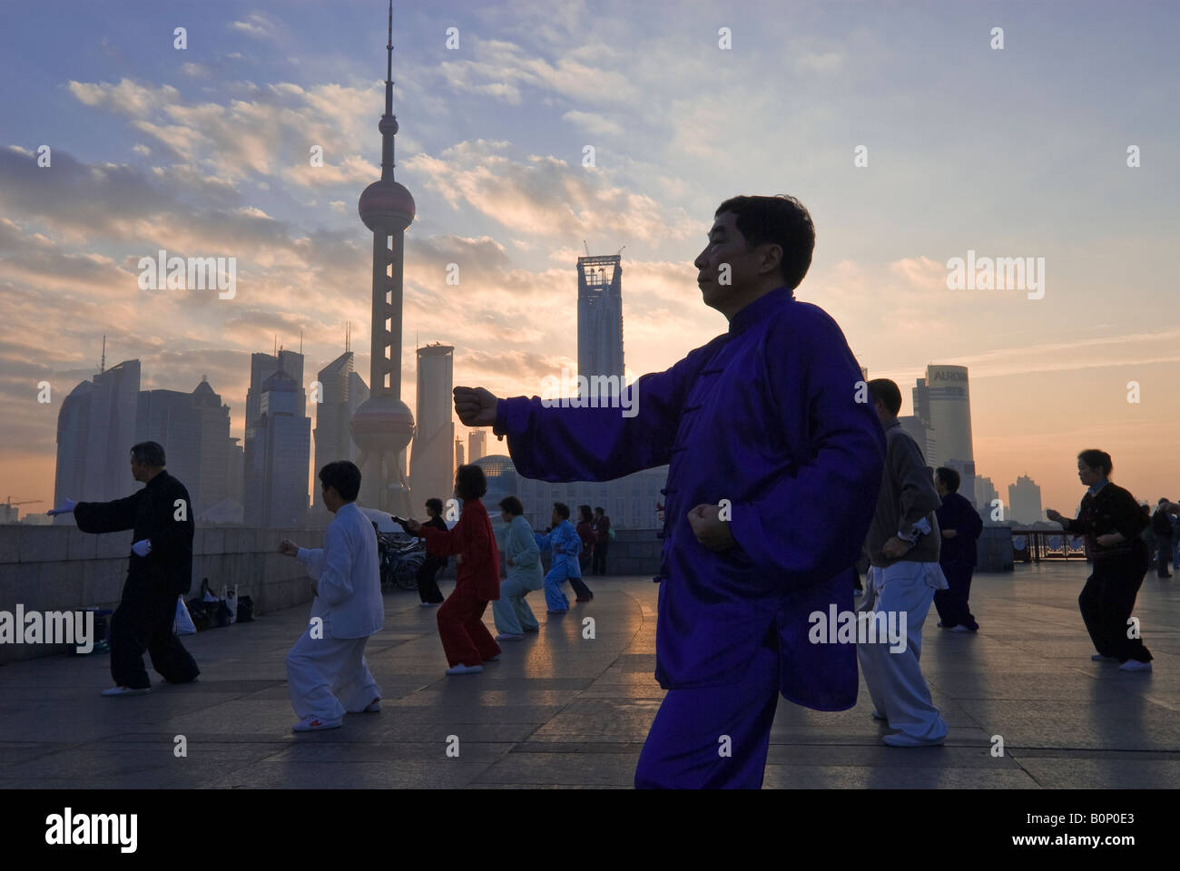 Kostümierte Tai Chi Praktizierenden bei Morgengrauen Skyline, Bund, Shanghai, China Stockfoto