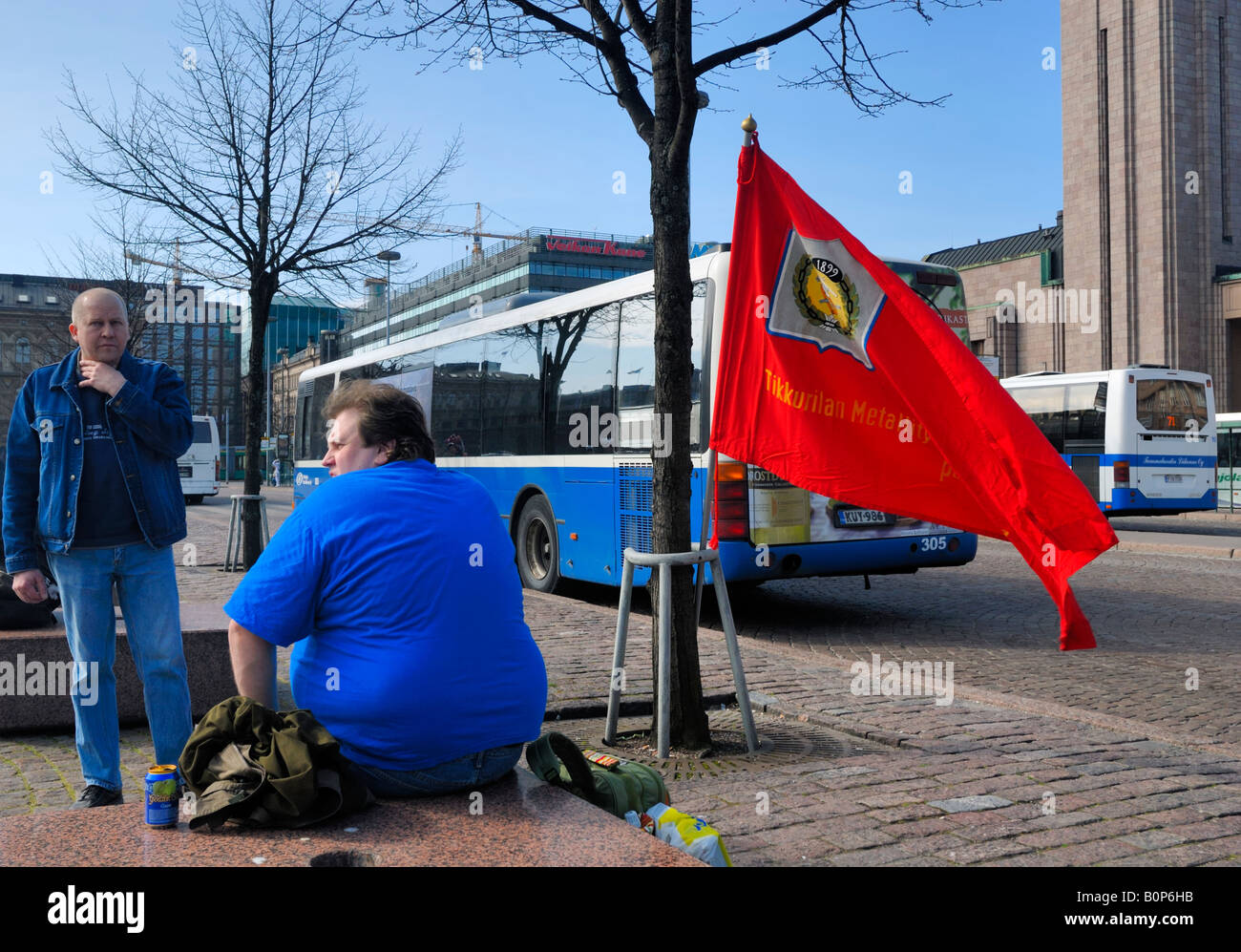 Die Demonstranten zu zögern mit roten Gewerkschaft Flagge vor der finnischen Gewerkschaft, SAK, May Day Parade, Helsinki, Finnland. Stockfoto