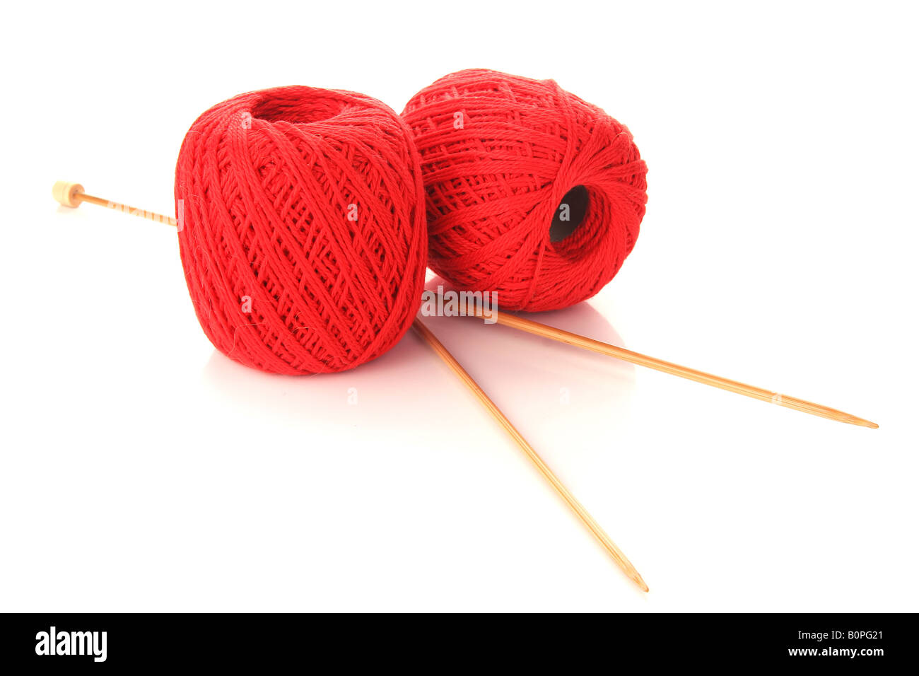 Zwei Kugeln aus Wolle mit Stricknadeln Stockfoto