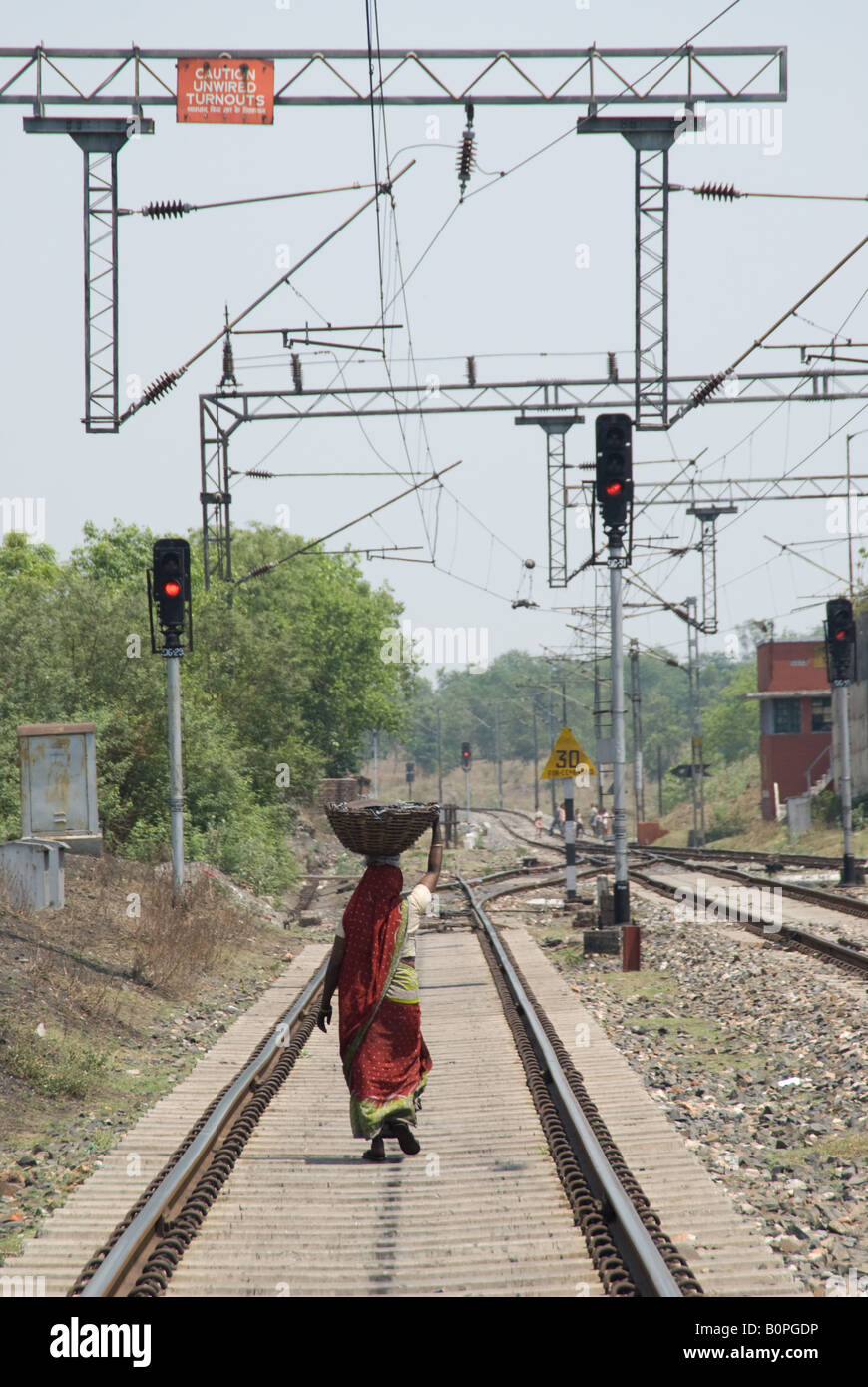 Frau Spaziergänge entlang der Gleise mit Belastung von illegal abgebaute Kohle, Indien. Stockfoto