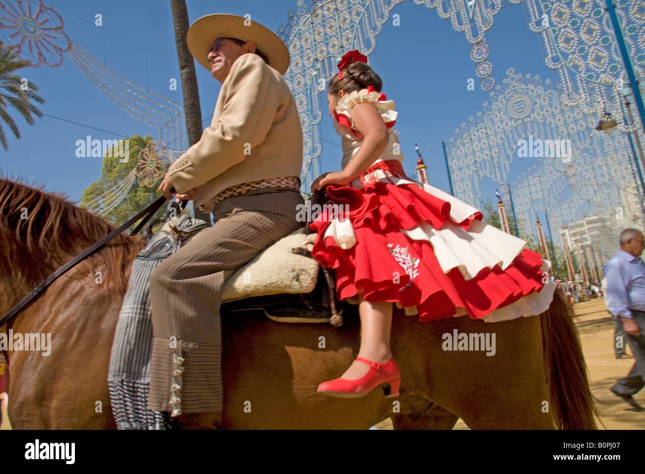 Mann und junge Mädchen auf dem Pferderücken, Jerez (Feria del Caballo) Stockfoto