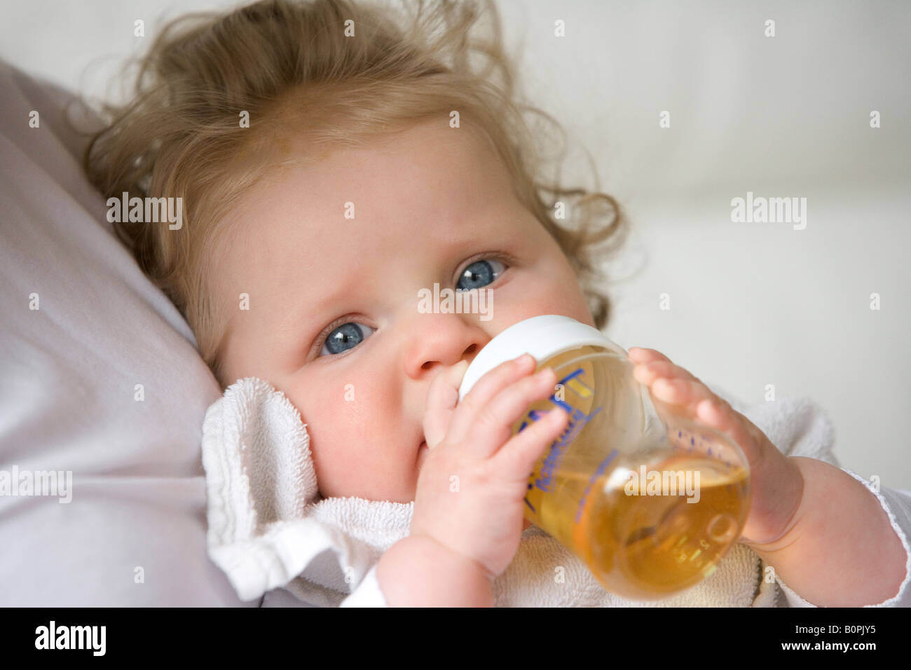 Babymädchen trinkt aus der Flasche Stockfoto