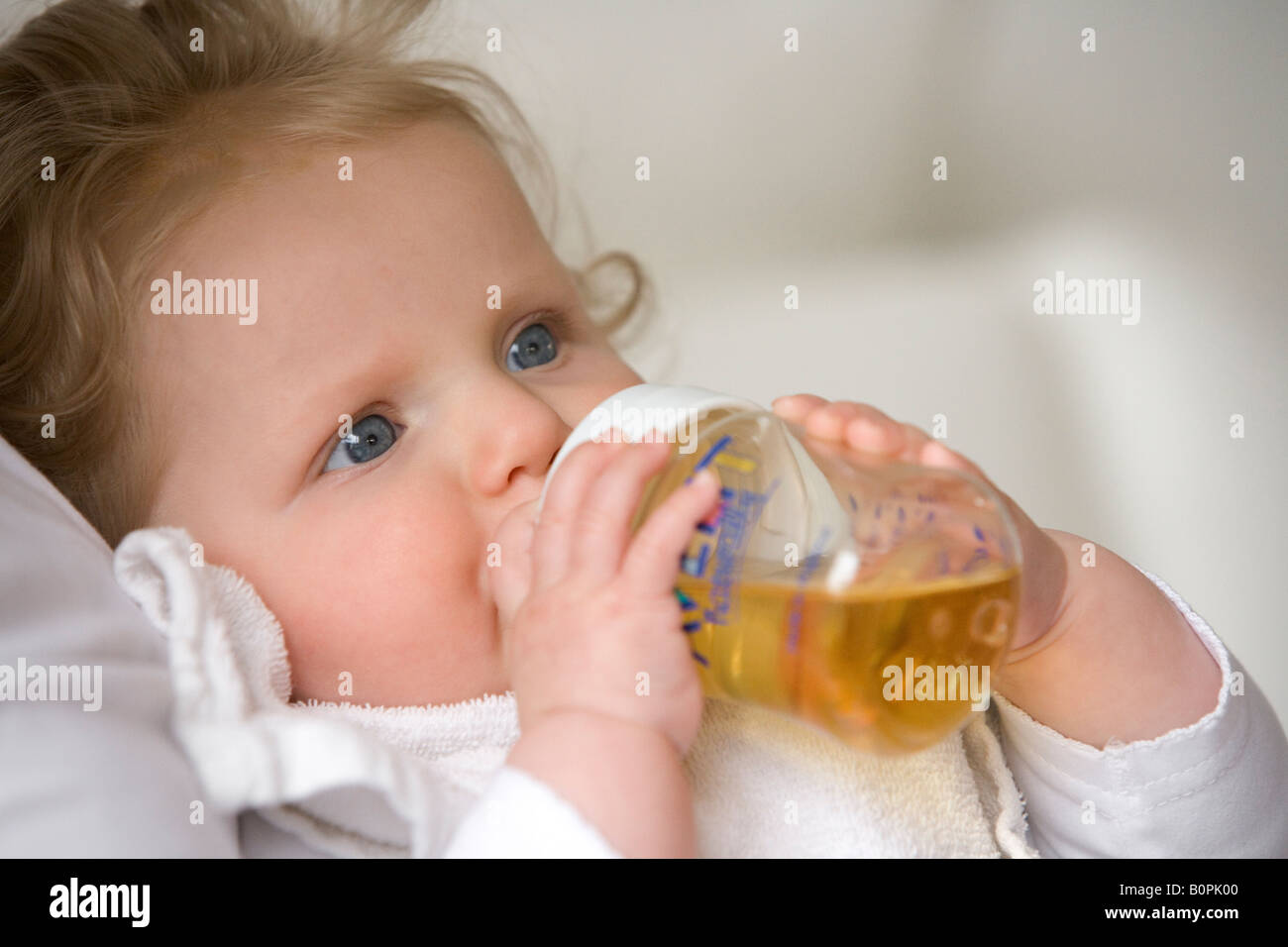 Babymädchen trinkt aus der Flasche Stockfoto
