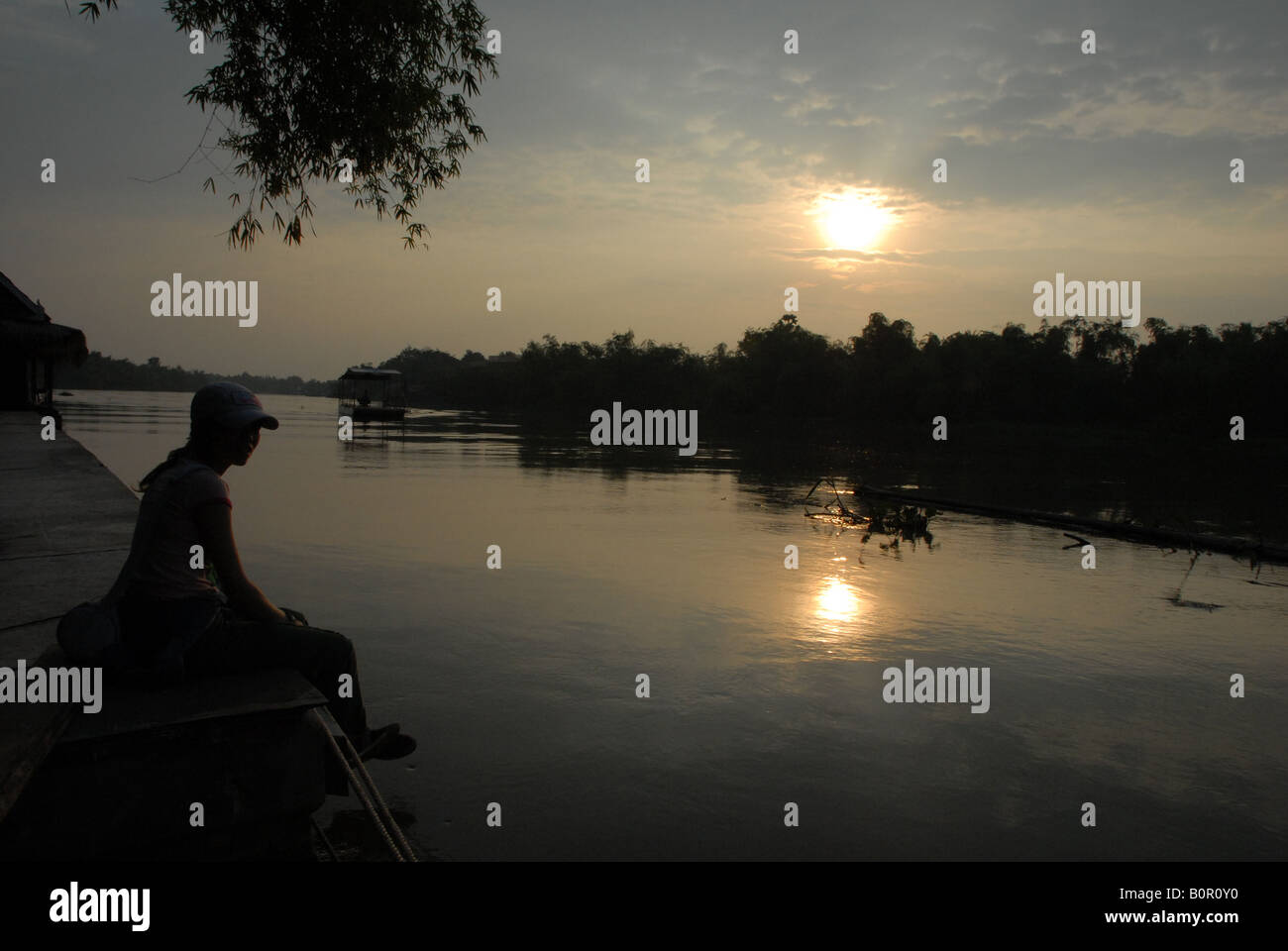 Thai Dame genießt den Sonnenuntergang am Sakaekrang River in Uthaithani, thailand Stockfoto