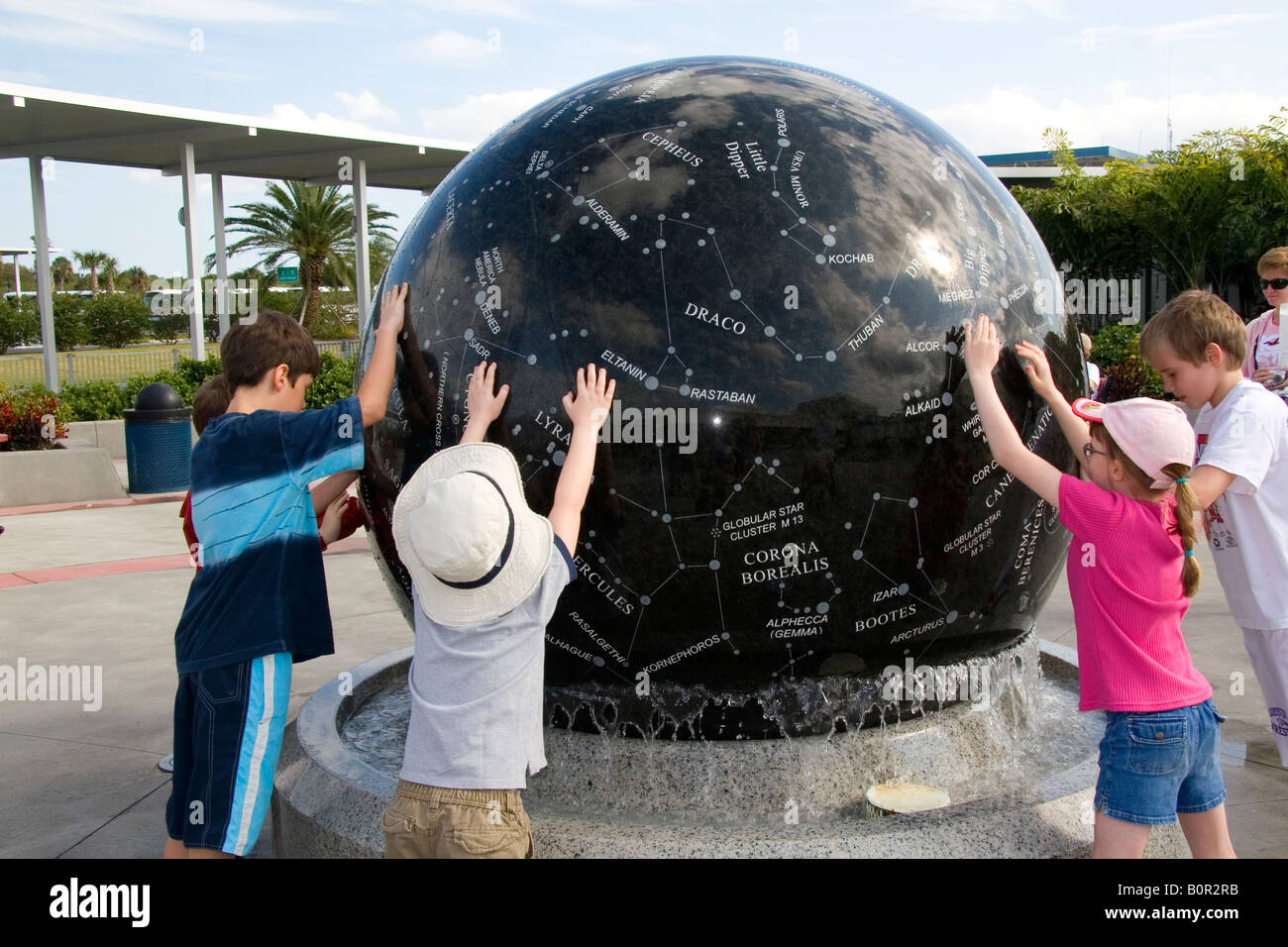 Kinder drücken die Konstellation Kugel auf dem Kennedy Space Center Visitor Complex in Cape Canaveral Florida Stockfoto