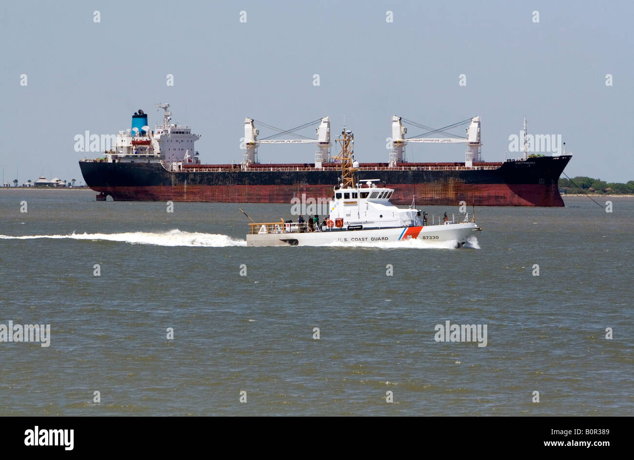 Bulk-Frachtschiff und U S Küstenwache Patrouillenboot in Galveston Bucht, Texas Stockfoto