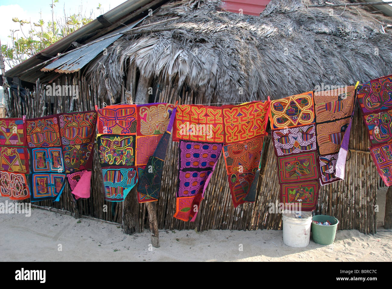 Eine Linie von Molas zum Verkauf vor einem Palapa auf der Kuna Yula traditionelle Insel Isla Tigre auf den San Blas Inseln Panama Stockfoto