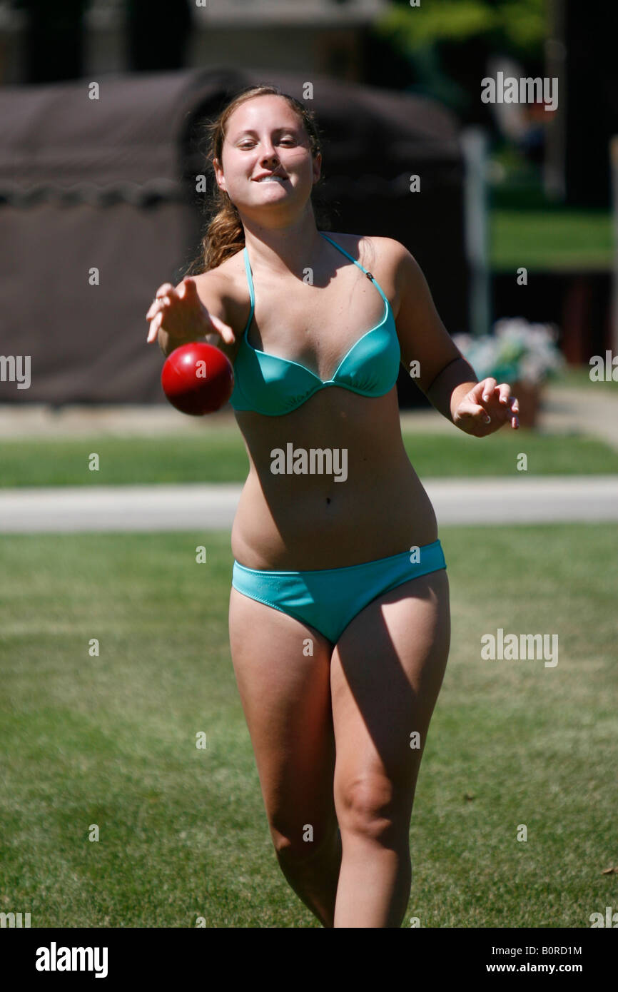 Teenager-Mädchen eine rote Kugel auf dem Hof zu werfen. Stockfoto