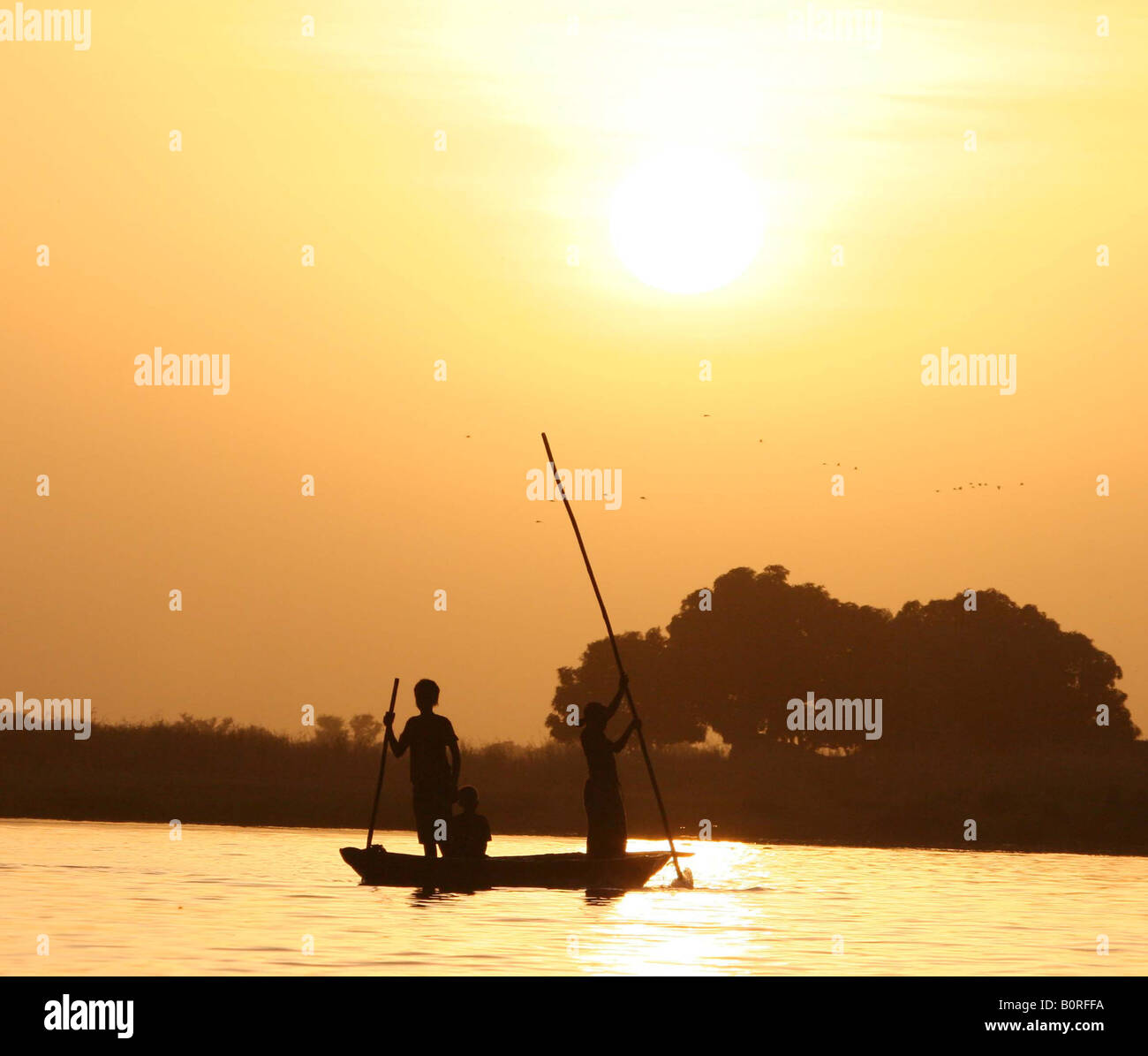 Kanu mit zwei Fischer, die Überquerung eines Flusses bei Sonnenuntergang Stockfoto