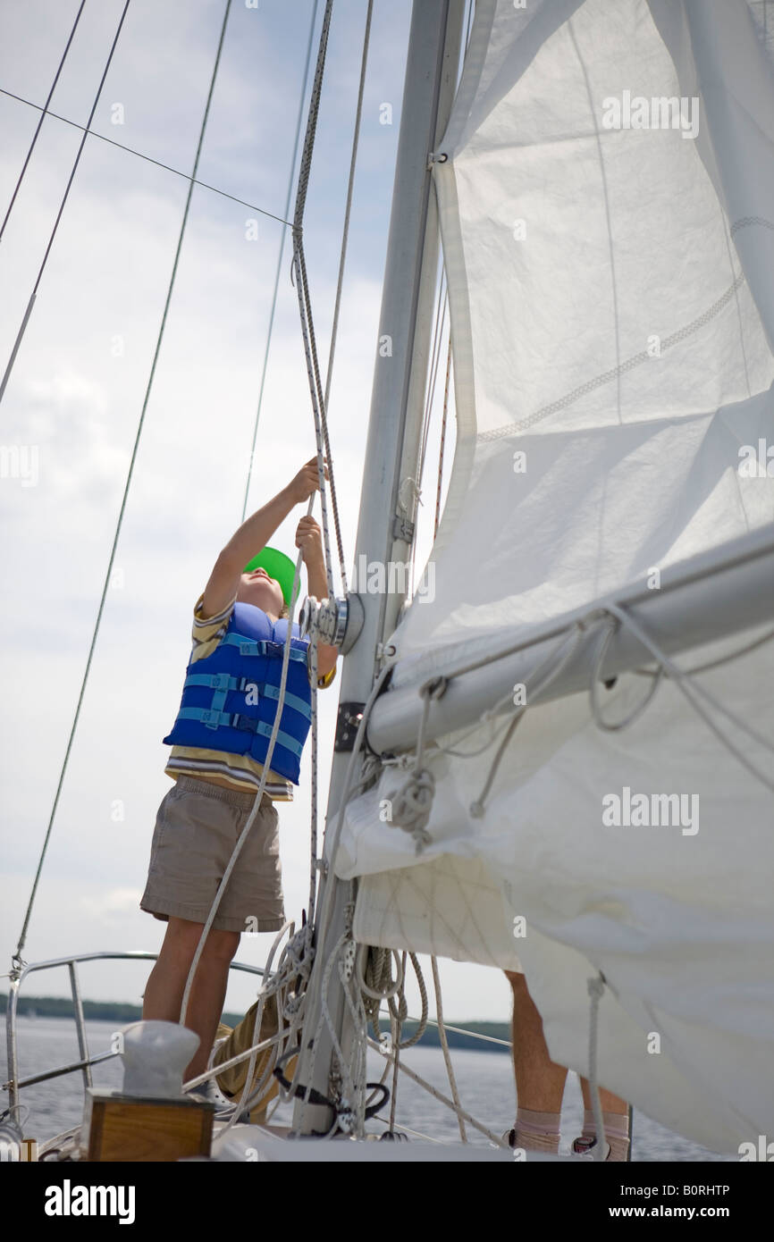 8 Jahre alter Junge mit am Bug Segelboot segeln Wind Yacht Wetter Reise Stockfoto