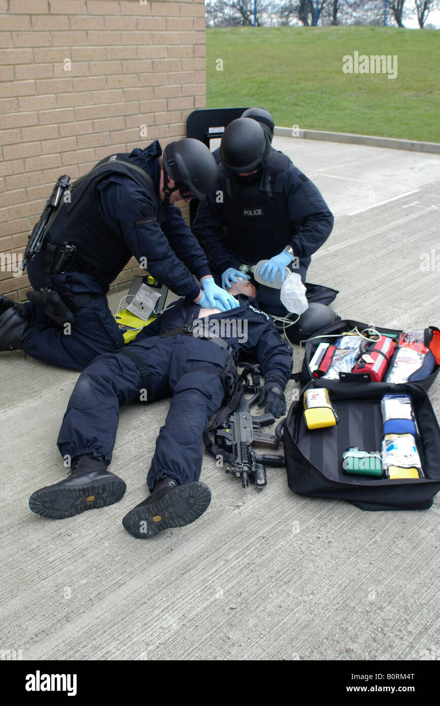 Polizisten Schusswaffen medizinische Hilfeleistung für verletzte Offizier Stockfoto