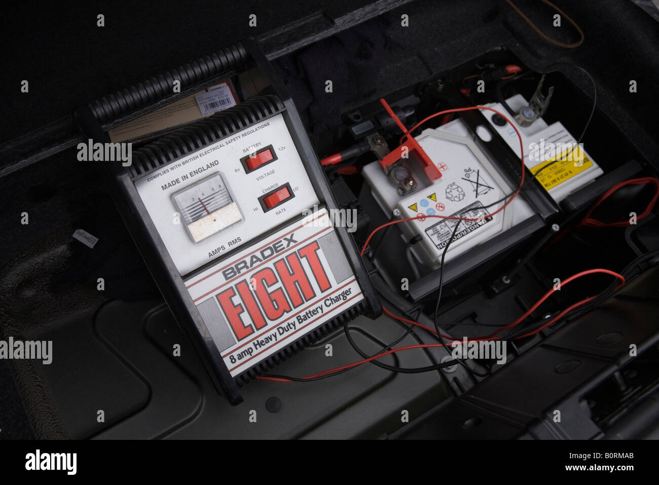 Eine rote Lade Draht- und Krokodil Clip führt zu den Pluspol einer flachen  12v Autobatterie in einem BMW Z4-Auto Stockfotografie - Alamy