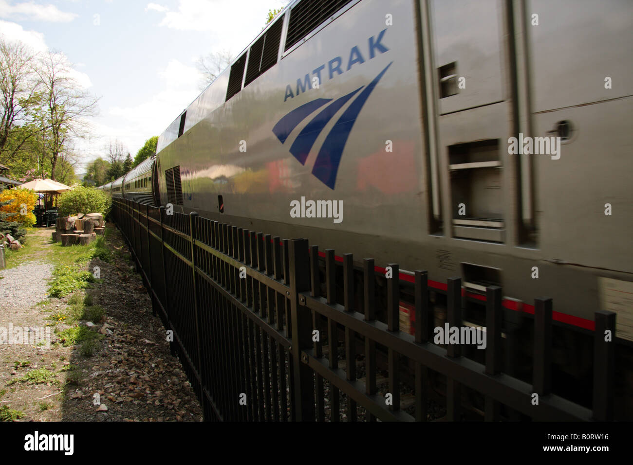 Ein Amtrak Zug eilt durch eine kleine station Stockfoto