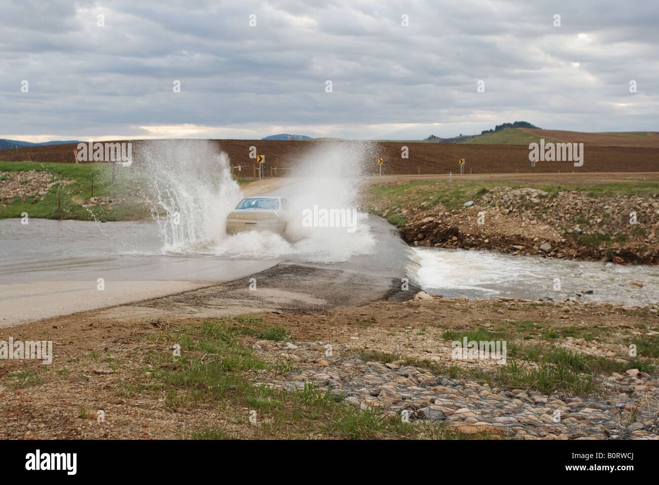 Auto über überflutete Straße nach Mai Blizzard gefolgt von mehreren Tagen Regen in Spearfish South Dakota Stockfoto