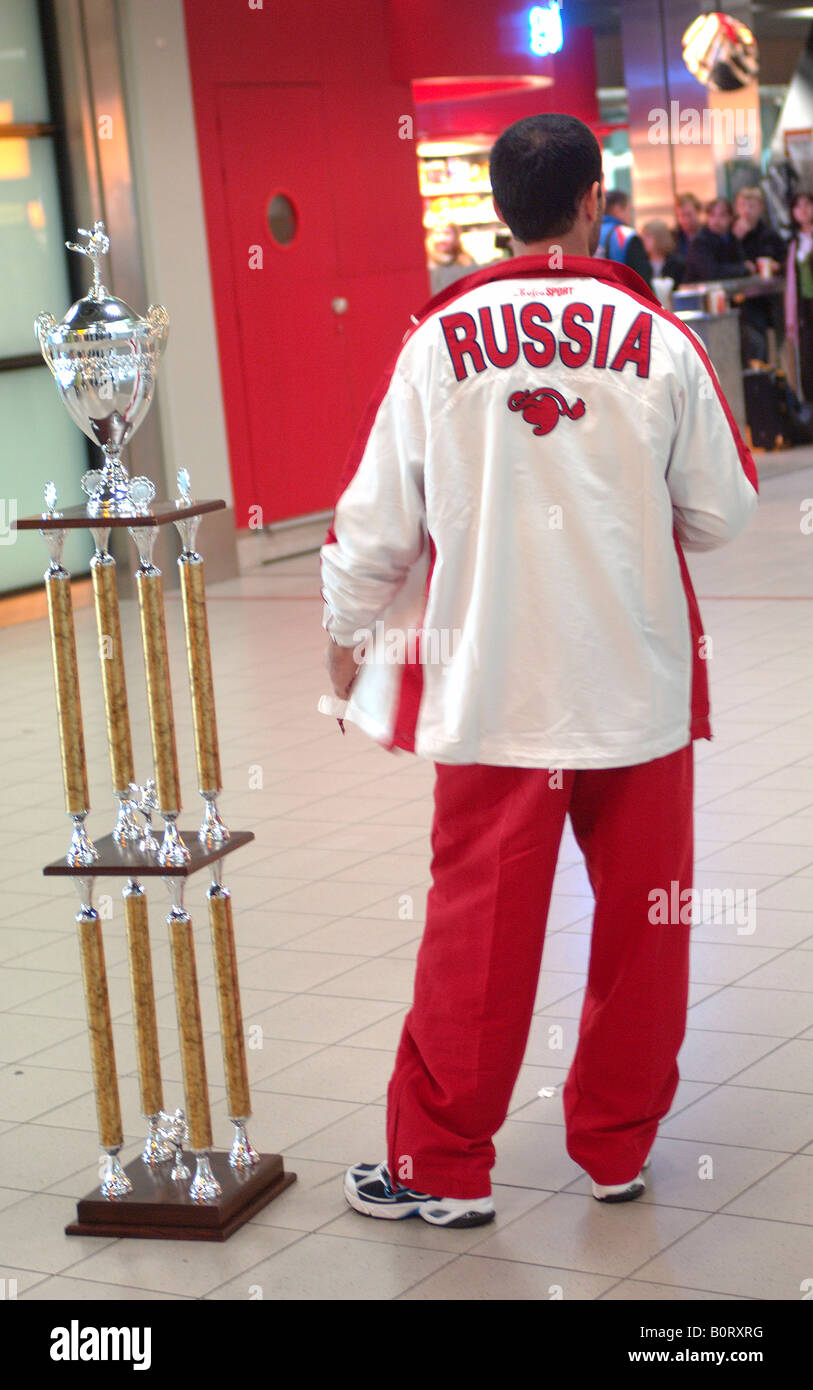 Amsterdam Schiphol Airport ein Athlet aus Russland mit einer Trophäe warten auf den Flug zurück nach Hause Stockfoto
