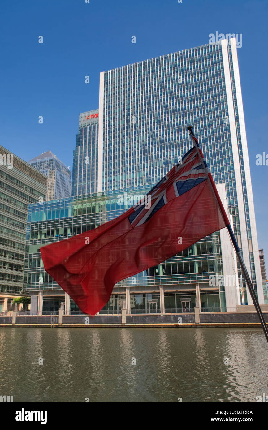 Die Red Ensign Großbritanniens Zivil- oder Händler Schiffe mit den modernen Türmen der Canary Wharf in London Uk Stockfoto