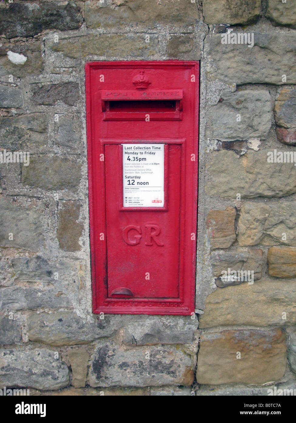 Ländliche britische Briefkasten in Wand in Landschaft Stockfoto