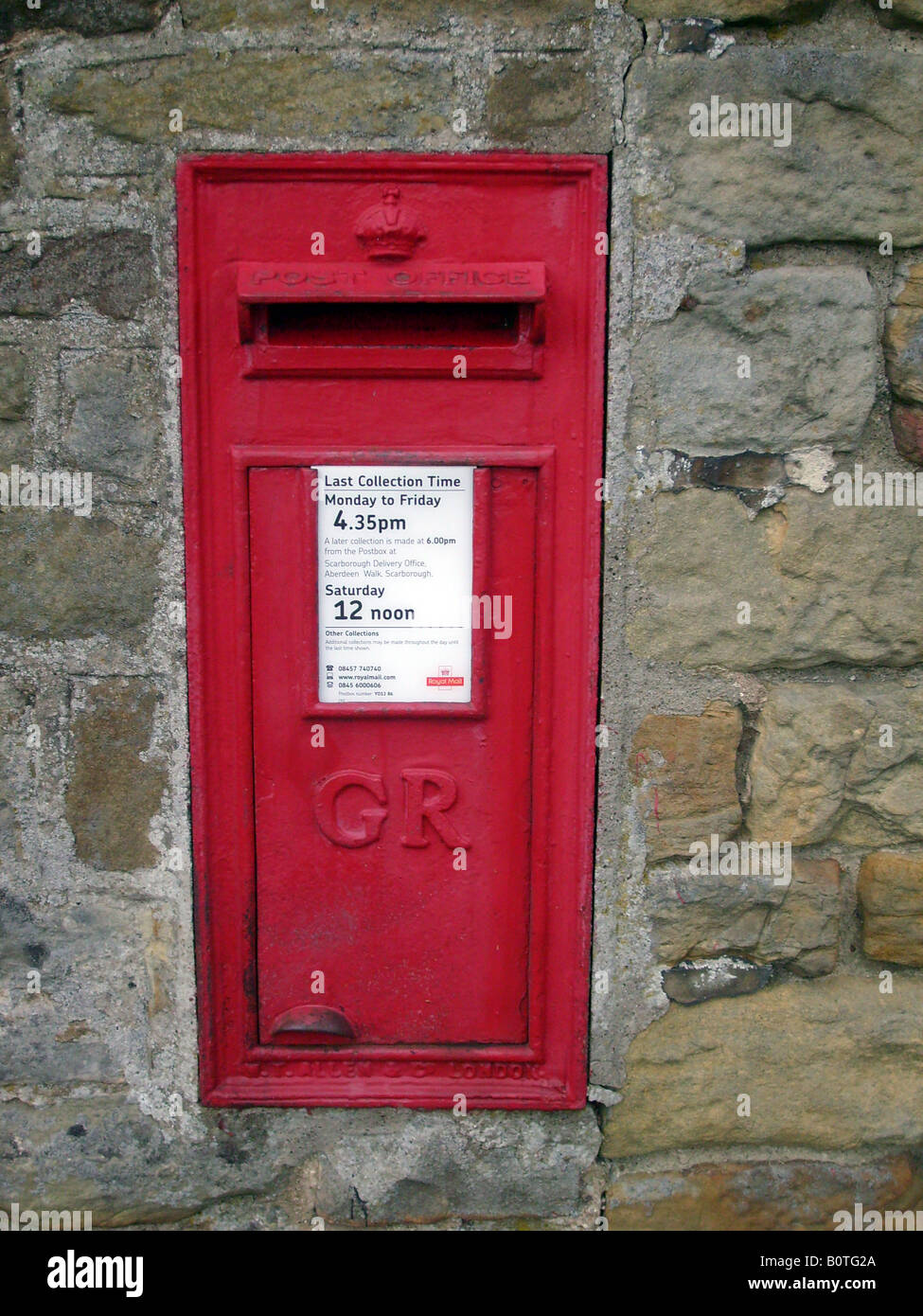 Ländliche britische Briefkasten in Wand in Landschaft Stockfoto