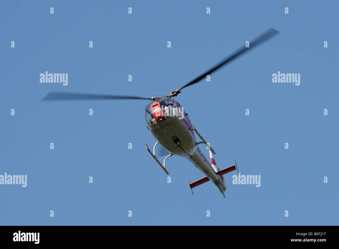 Kleine rote Hubschrauber fliegen im blauen Himmel Potton Bedfordshire Stockfoto