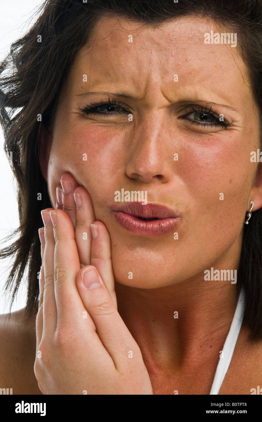 Eine junge Frau leidet Zahnschmerzen oder Mund Geschwür Art Krankheit reiben ihre Wange zur Linderung von Schmerzen und Beschwerden Stockfoto