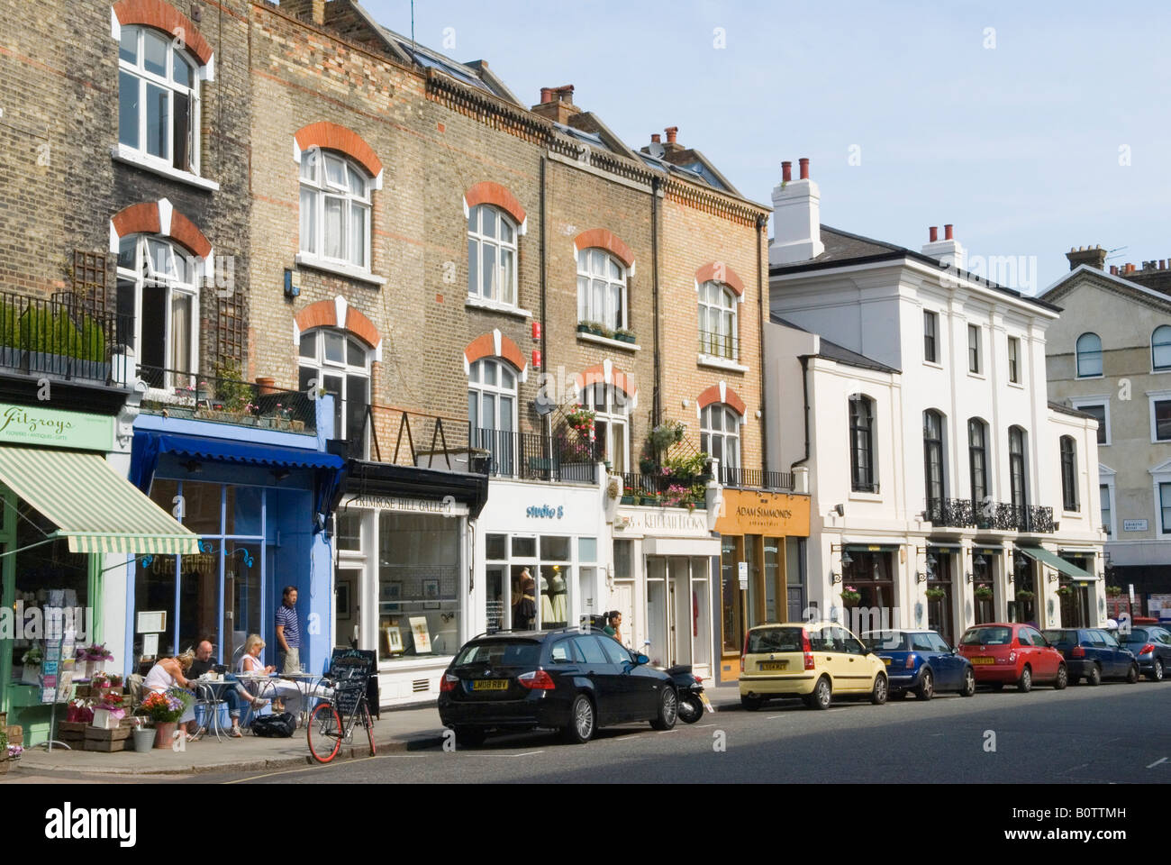 Primrose Hill, Regents Park Road Geschäfte und Café. Leute, die einen Kaffee genießen, sitzen vor einem Café. London, England, 25. Mai 2008. HOMER SYKES Stockfoto