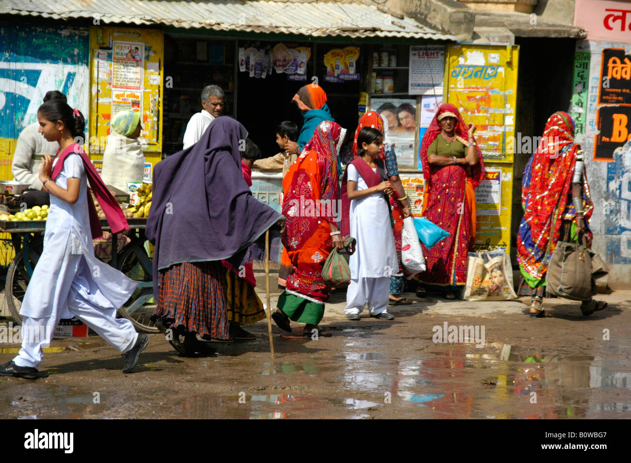 Bunte Straßenbild von Menschen vor einer Wand bedeckt in der Werbung, Lachmangarh, Rajasthan, Indien Stockfoto