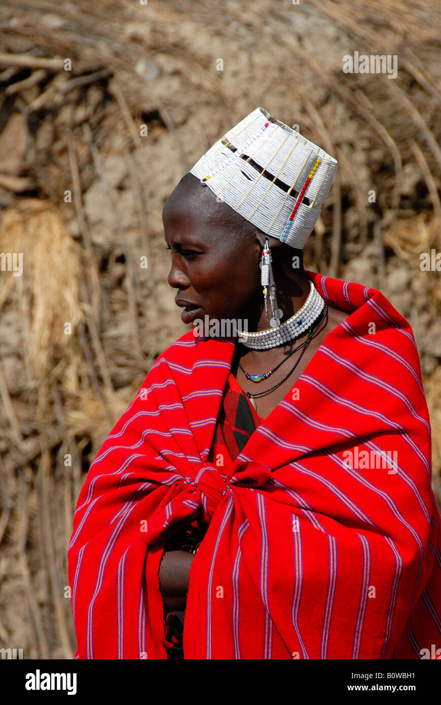 Masai Frau in einem roten Tuch gewickelt und trägt einen weißen Kopf Hut, Serengeti, Tansania, Afrika Stockfoto