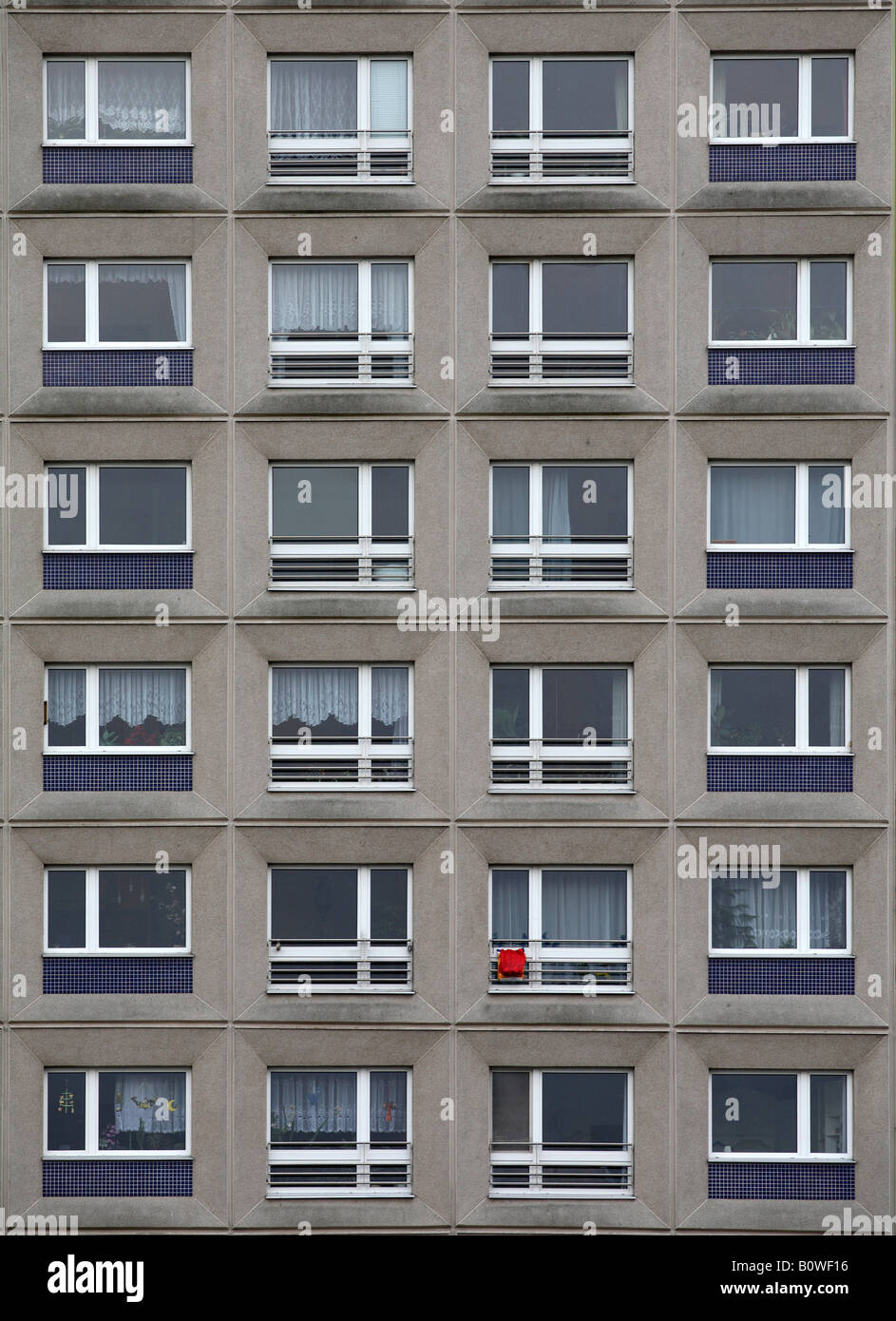 Grauer Beton Apartment Block Fassade, Stück rote Wäsche, Berlin, Deutschland, Europa Stockfoto