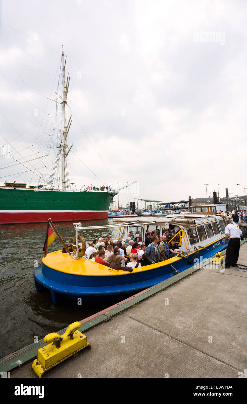 Sightseeing Touristen auf Boot am Hamburger Hafen, historische Segler "Rickmer Rickmers" im Hintergrund Stockfoto