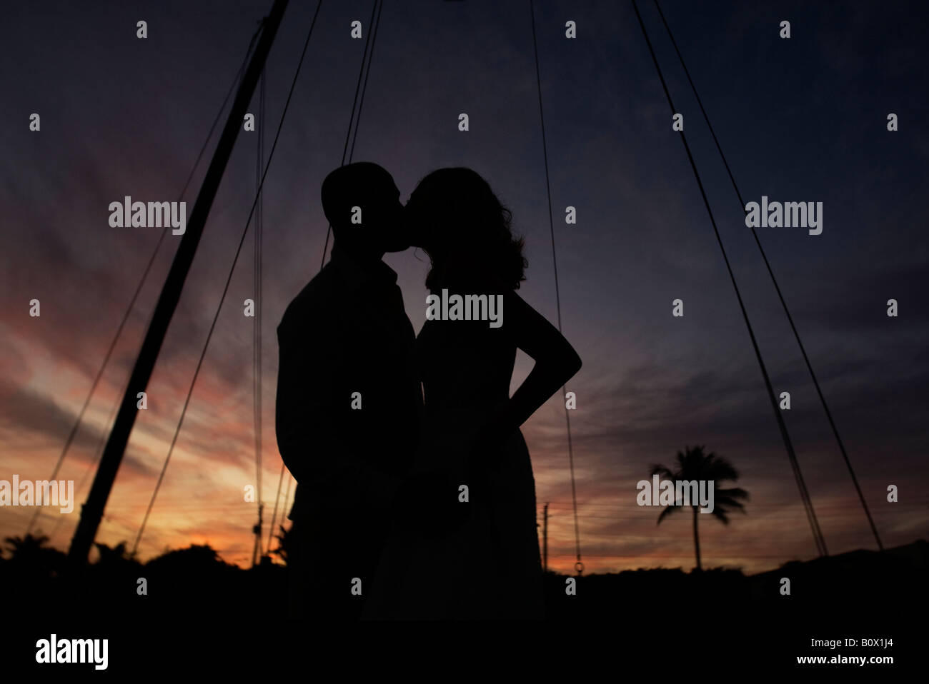 Paar Küssen auf einem Boot bei Sonnenuntergang. interracial Pärchen glücklich lächelnd Stockfoto