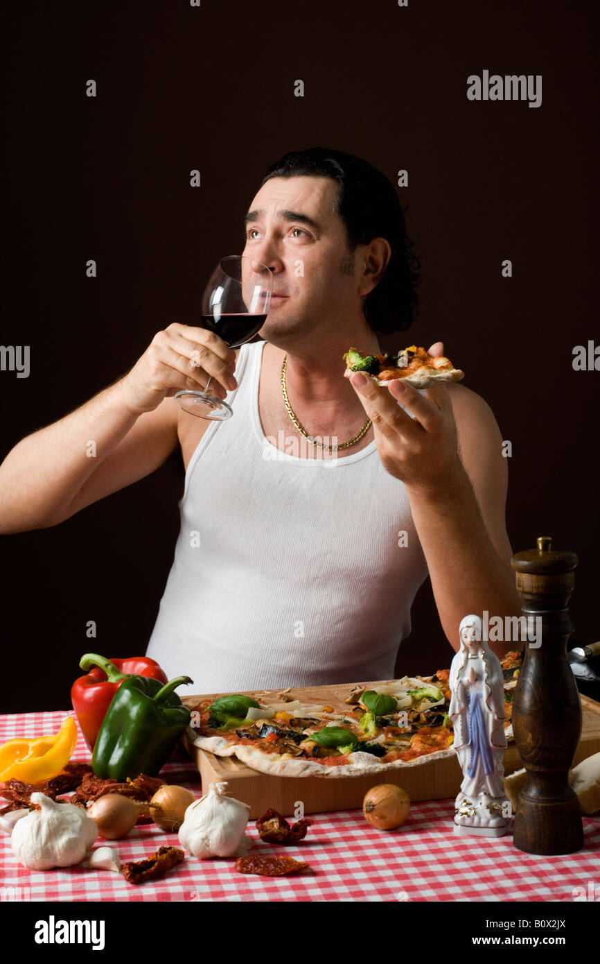 Stereotype italienischen Mann hält eine Glas Weine und Pizza essen Stockfoto