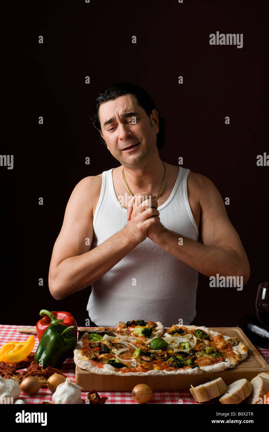 Stereotype italienischen Mann mit den Händen umklammert in Dankbarkeit auf eine pizza Stockfoto