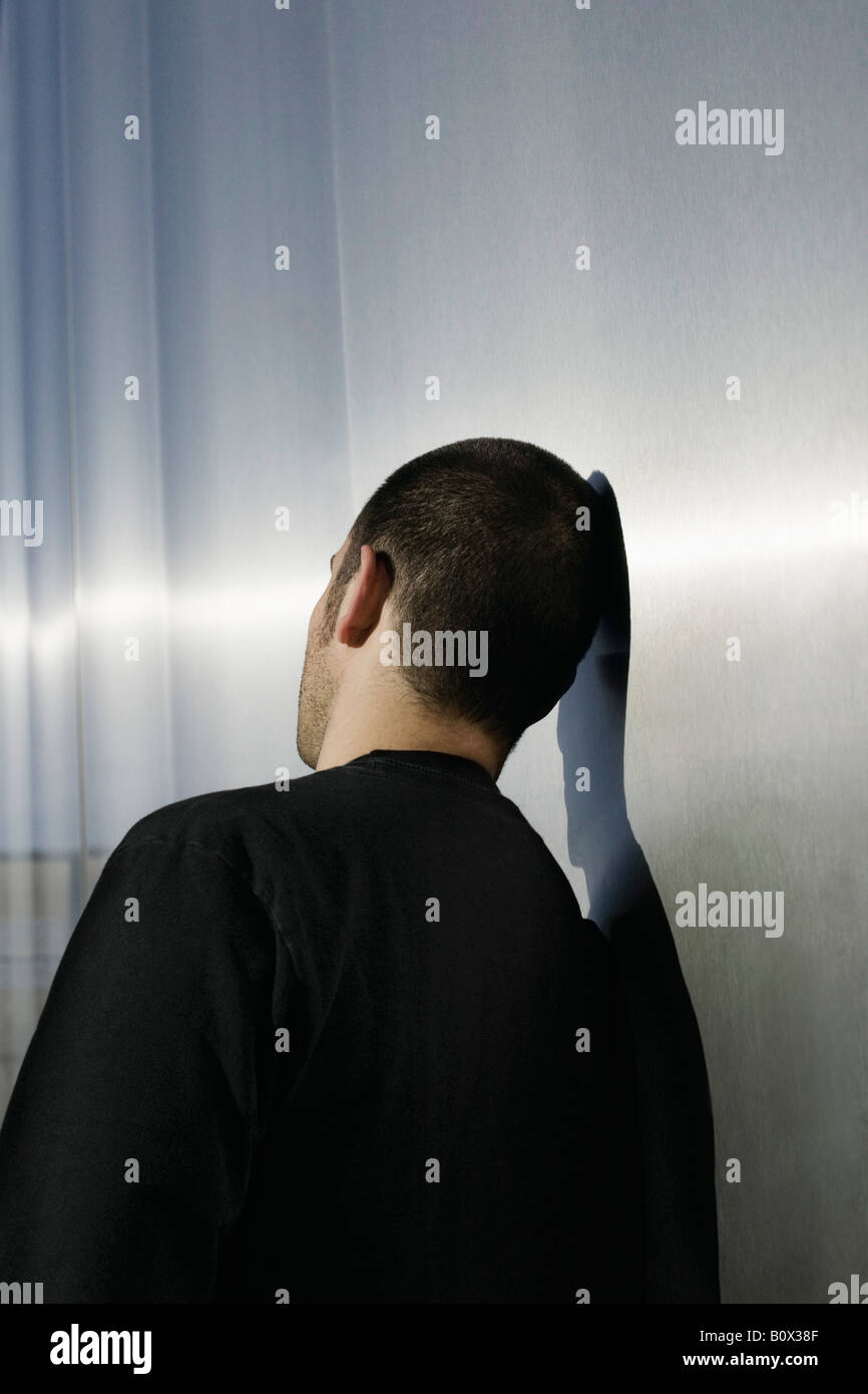 Ein Mann gegen eine Wand gelehnt Stockfoto