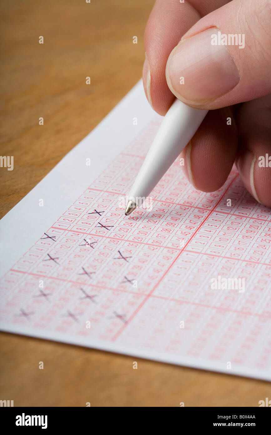 Eine Hand markieren einen Lottoschein Stockfoto