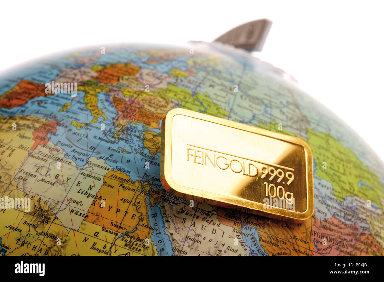 Goldbarren auf Globus Stockfoto