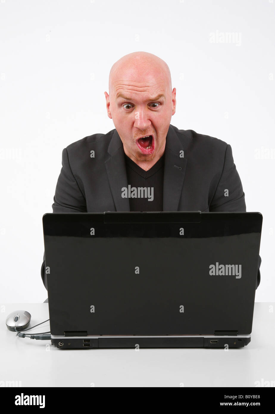 Glatze Mann sah entsetzt über seinen Laptop unter der Leitung Stockfoto