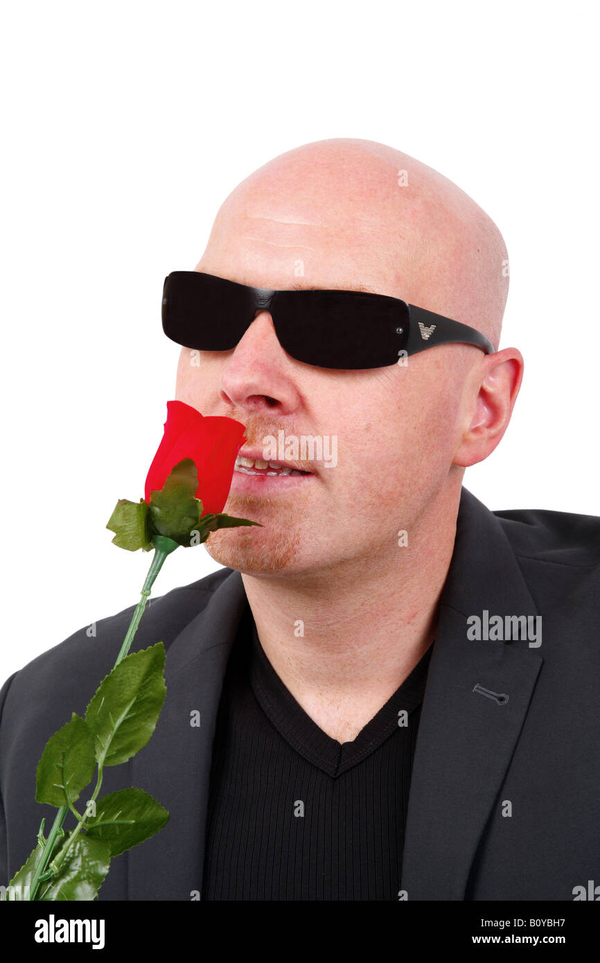Glatze Mann mit Sonnenbrille schnüffeln im roten Rose geleitet Stockfoto